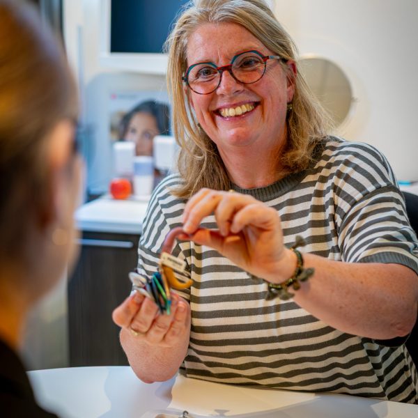 Medewerker van Van Rugge toont een hoortoestel in de winkel in Neede
